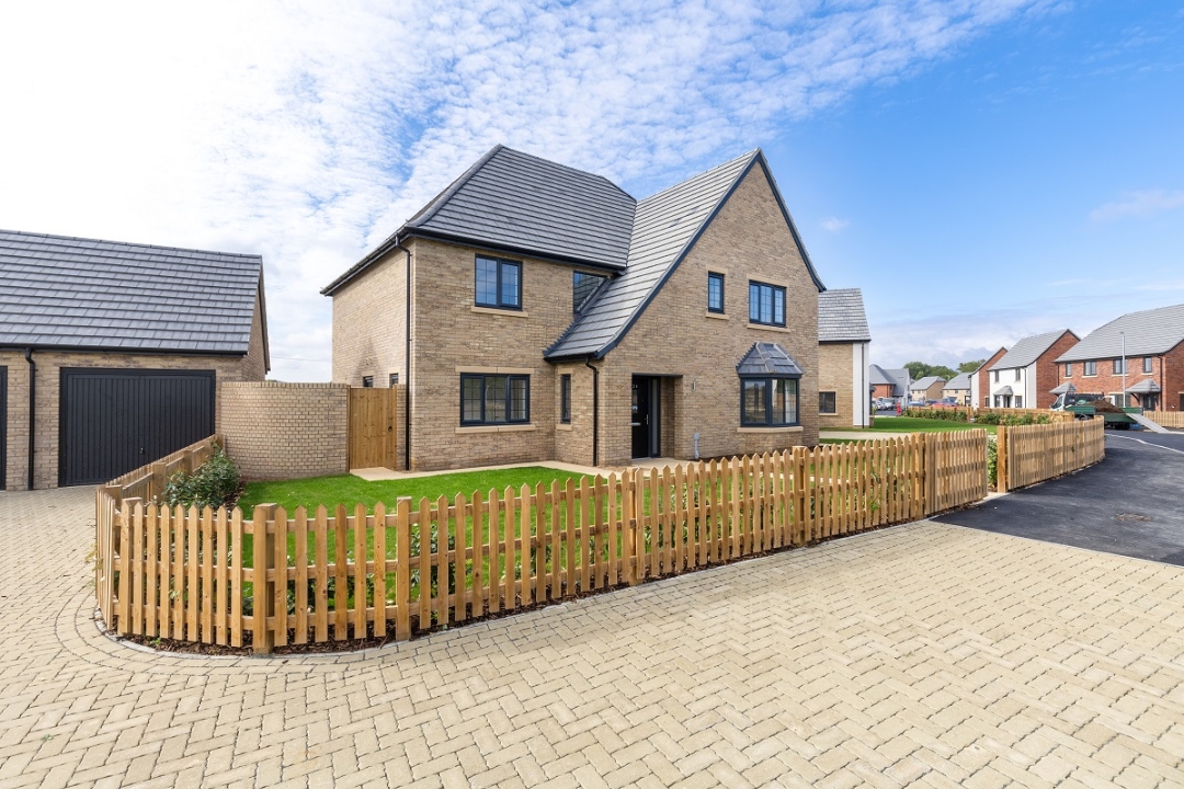 Exterior image of The Royston, a large detached family home with a front garden surrounded by a wooden picket fence