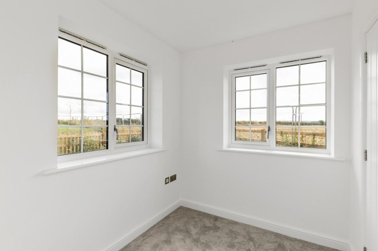 A smaller bedroom at the corner of the house with two windows