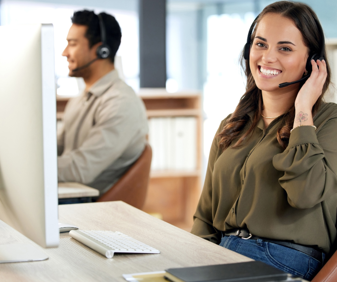 Two colleagues working in a call centre environment 